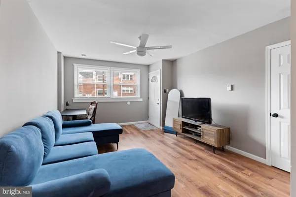 a living room with furniture a flat screen tv and a window