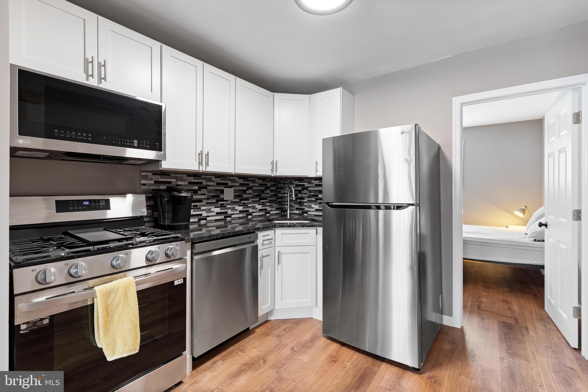 331 Ripka Street, Unit 1 Philadelphia, PA 19128 - Photo 5 of 8 a kitchen with stainless steel appliances a refrigerator stove and microwave