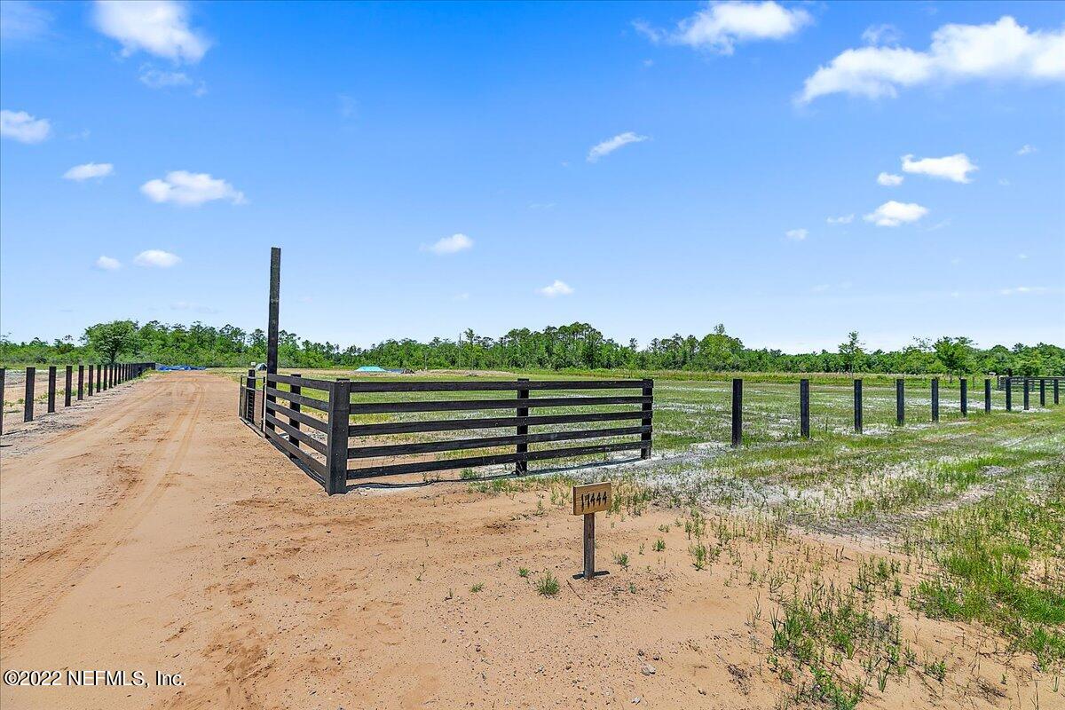 a view of a road with wooden fence