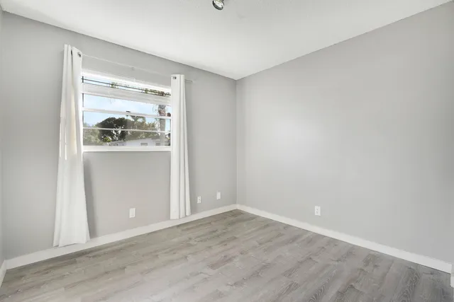a view of a room with wooden floor & cabinets