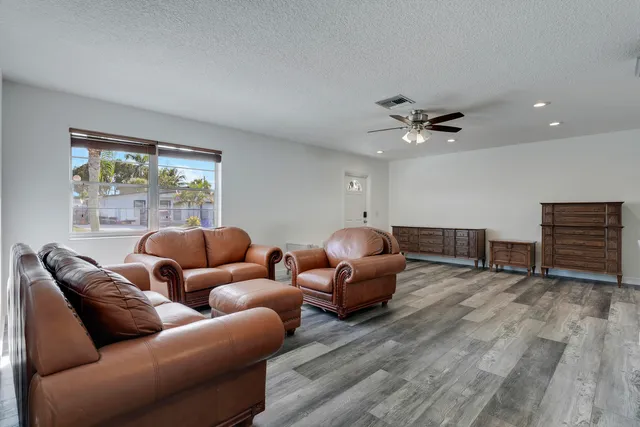 a living room with furniture ceiling fan and a window
