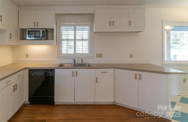 a kitchen with granite countertop white cabinets and a sink