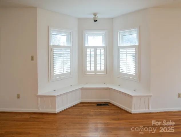 a view of an empty room with window and a fireplace