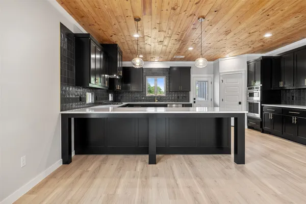 a kitchen with kitchen island granite countertop a sink cabinets and stainless steel appliances