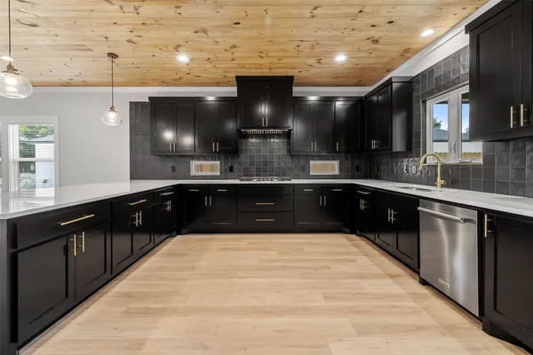 a large kitchen with stainless steel appliances wooden cabinets and a counter top space