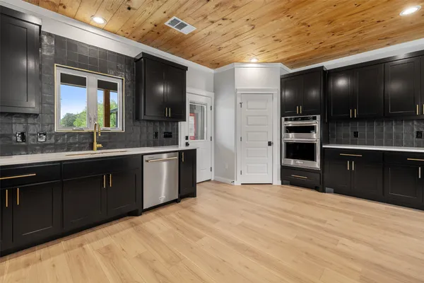 a kitchen with stainless steel appliances kitchen island granite countertop a sink and cabinets