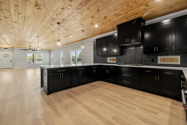 a kitchen with stainless steel appliances kitchen island granite countertop a sink counter space and cabinets