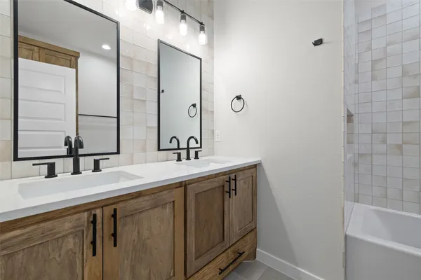 a bathroom with a double vanity sink and a bathtub