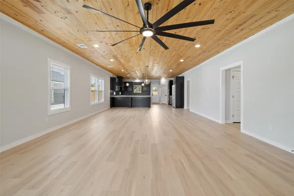 a view of a livingroom with a ceiling fan window and wooden floor