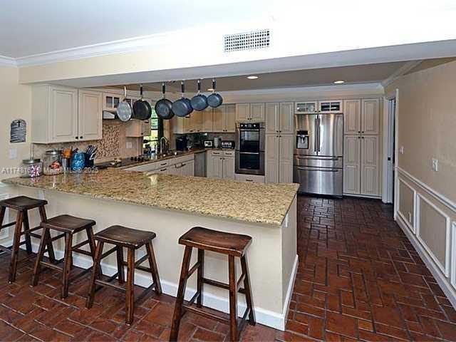 720 Mockingbird Lane Plantation, FL 33324 - Photo 4 of 12 a kitchen with stainless steel appliances granite countertop a sink and cabinets