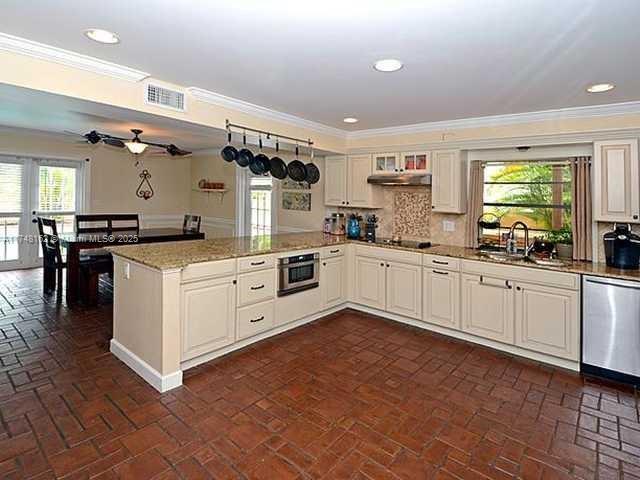 720 Mockingbird Lane Plantation, FL 33324 - Photo 5 of 12 a kitchen with white cabinets and white appliances