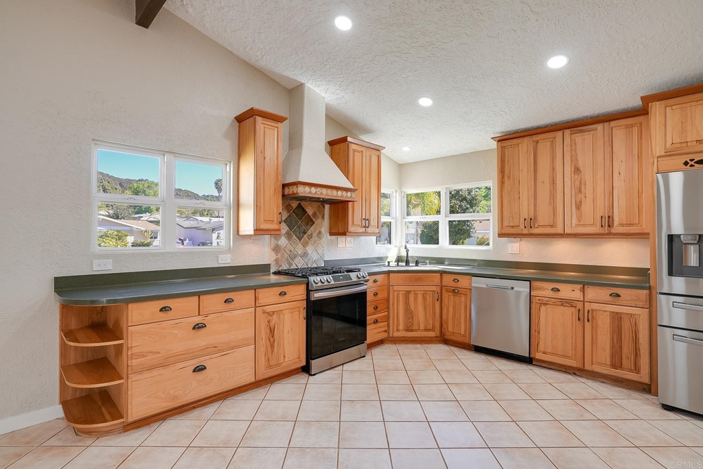 225 Hypoint Place Escondido, CA 92027 - Photo 13 of 63 a kitchen with stainless steel appliances granite countertop a stove a sink and a refrigerator
