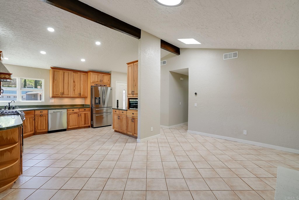 225 Hypoint Place Escondido, CA 92027 - Photo 17 of 63 a kitchen with stainless steel appliances a refrigerator sink and cabinets