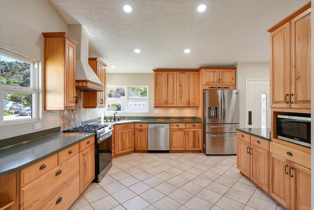 225 Hypoint Place Escondido, CA 92027 - Photo 2 of 63 a kitchen with stainless steel appliances granite countertop a refrigerator sink and cabinets