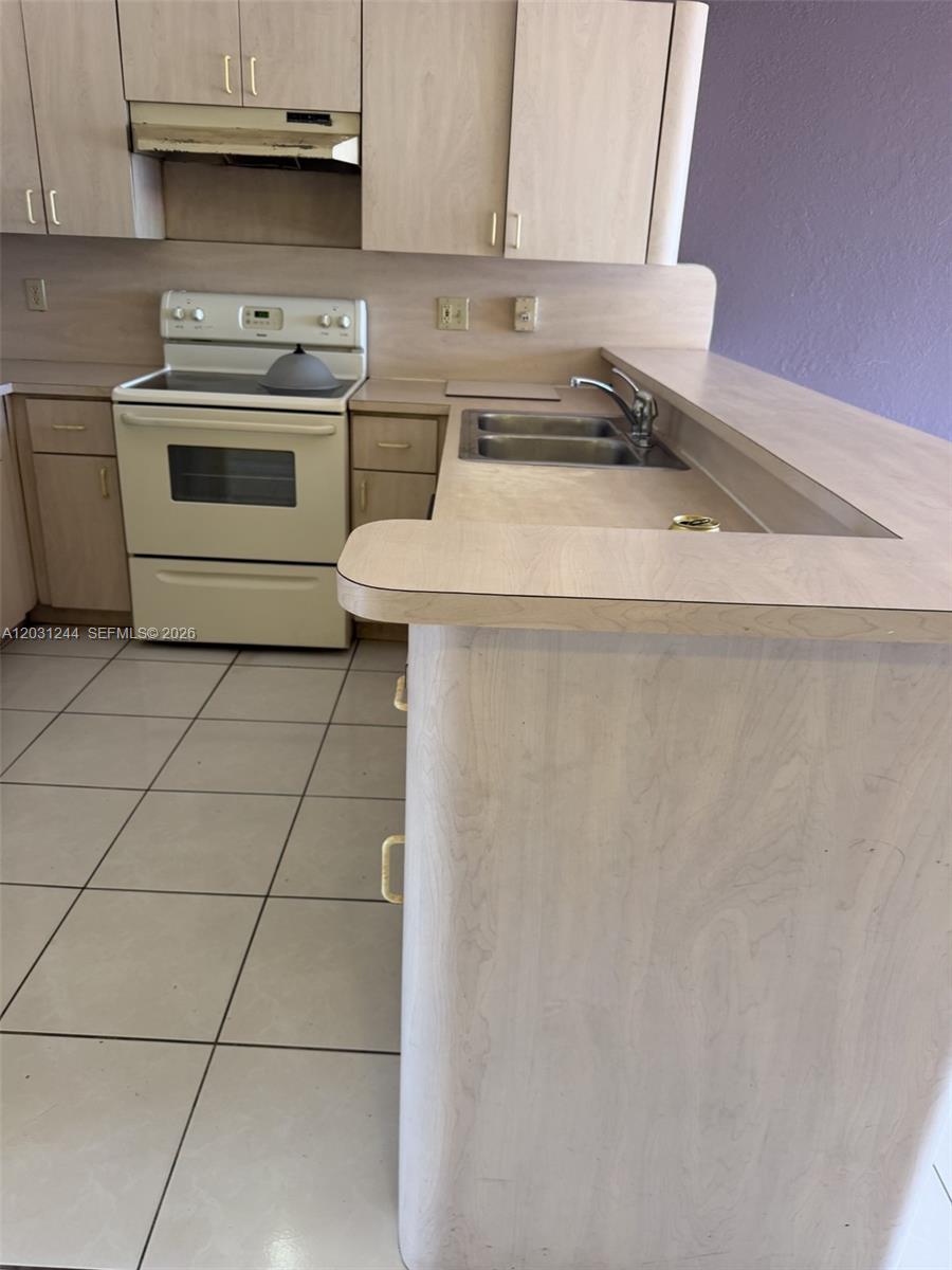 13752 Southwest 156th Street Miami, FL 33177 - Photo 6 of 14 a kitchen with granite countertop a sink a stove and cabinets