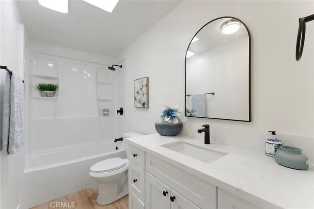 a bathroom with a toilet a sink a mirror and bathtub