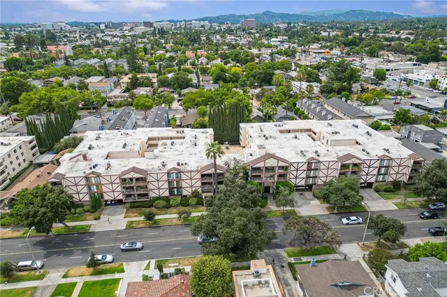 an aerial view of residential houses with outdoor space and parking