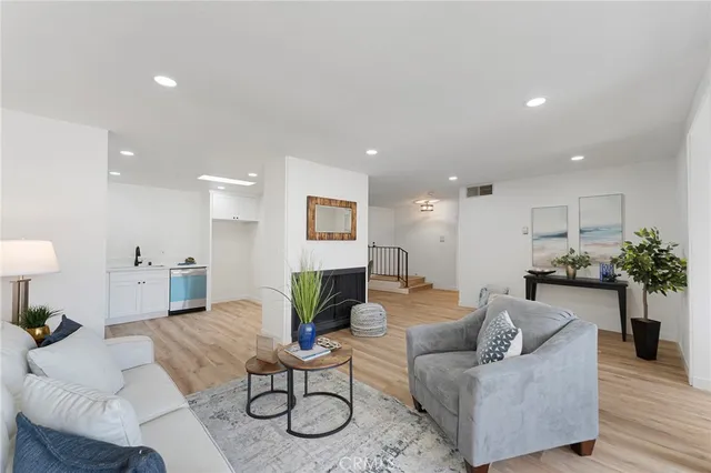 a living room with furniture kitchen view and a potted plant