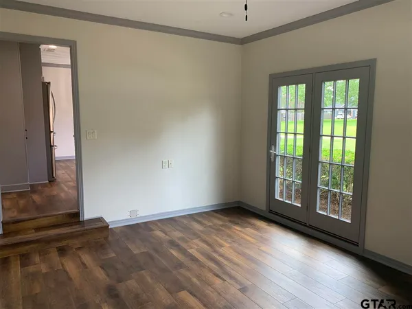 a view of an empty room with glass door and a window