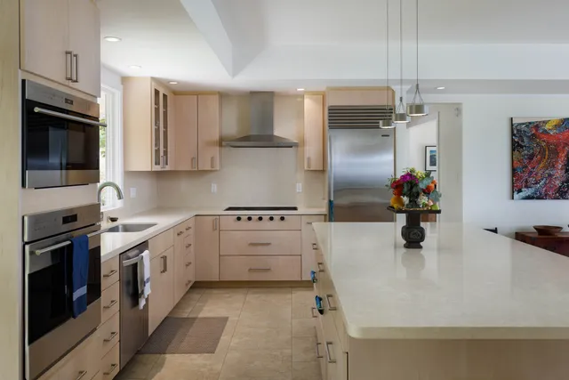 a kitchen with granite countertop a sink stainless steel appliances and cabinets