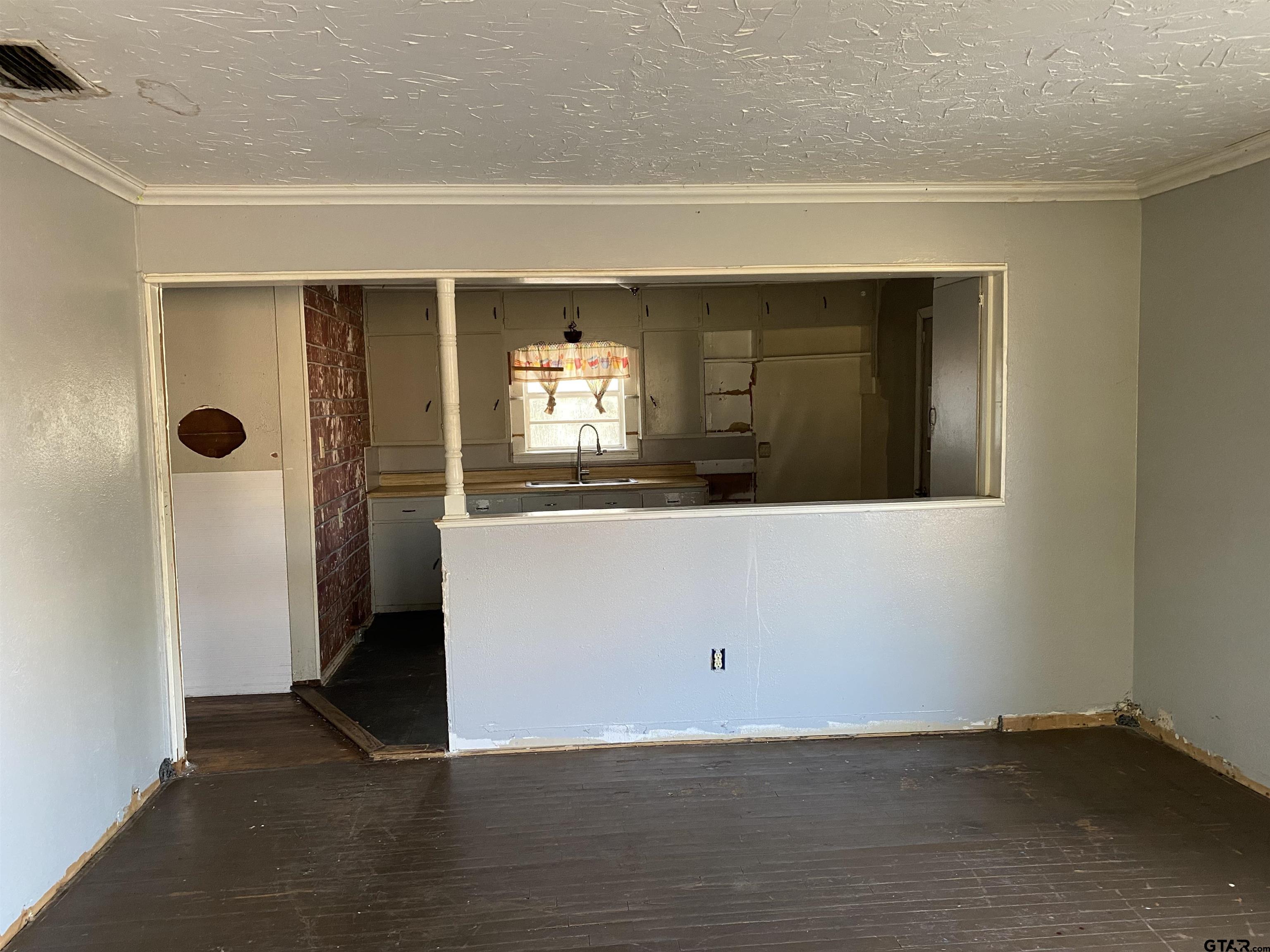 210 North Stephens Street Quitman, TX 75783 - Photo 3 of 28 an empty room with wooden floor and windows