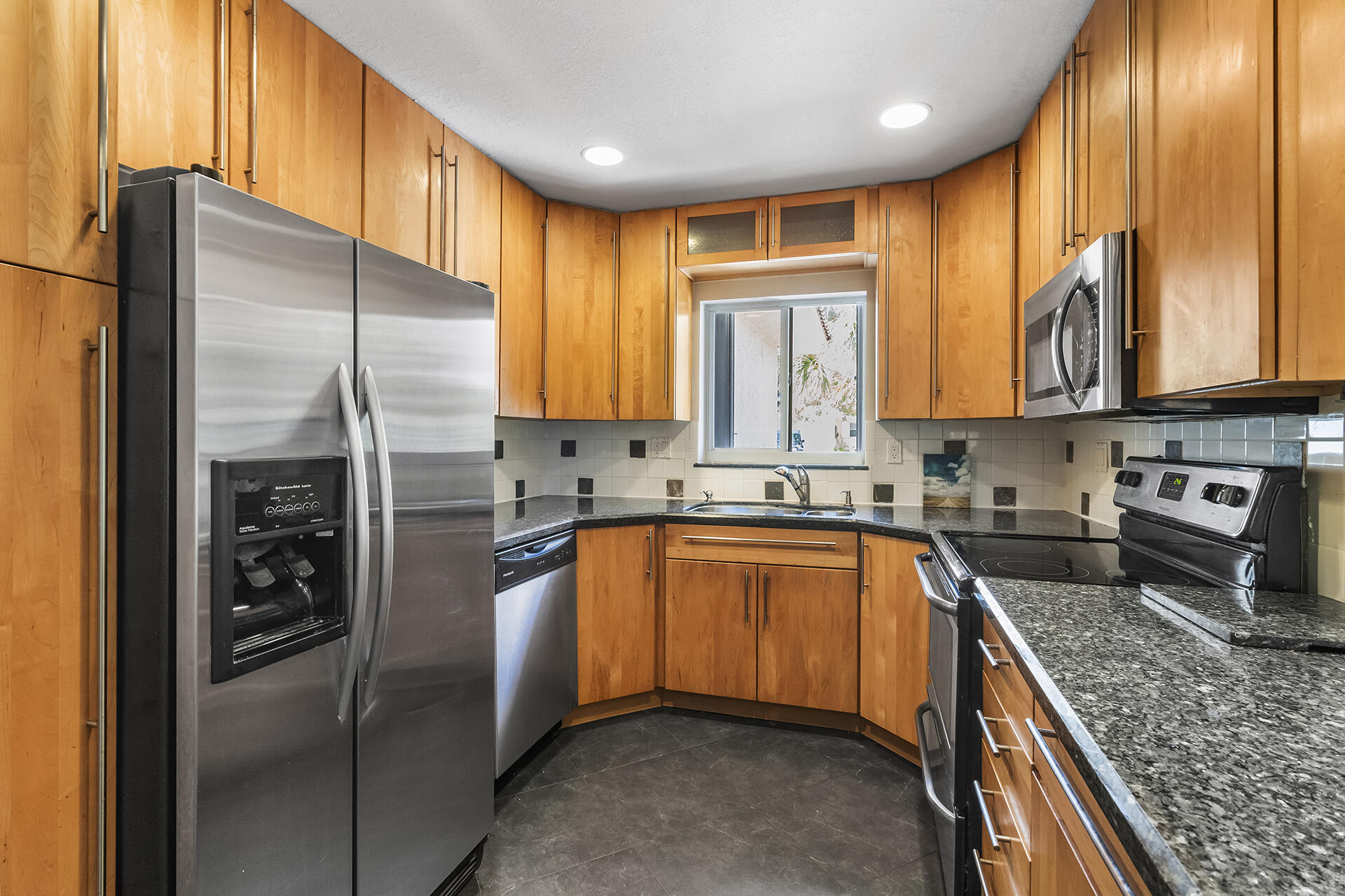 298 Northwest 11th Street Boca Raton, FL 33432 - Photo 9 of 21 a kitchen with stainless steel appliances granite countertop refrigerator a sink a stove top oven and cabinets