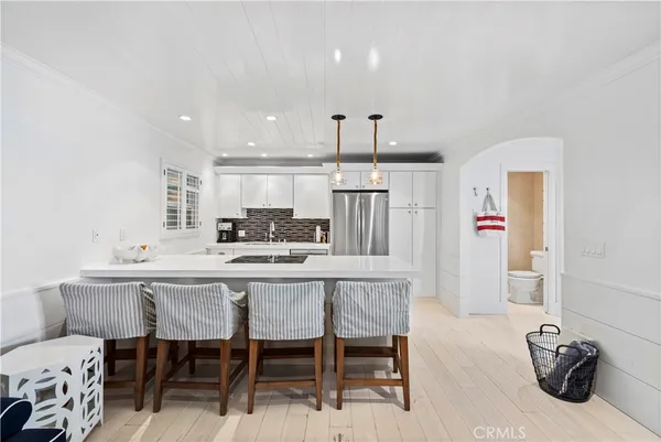 a kitchen with a dining table chairs refrigerator and sink