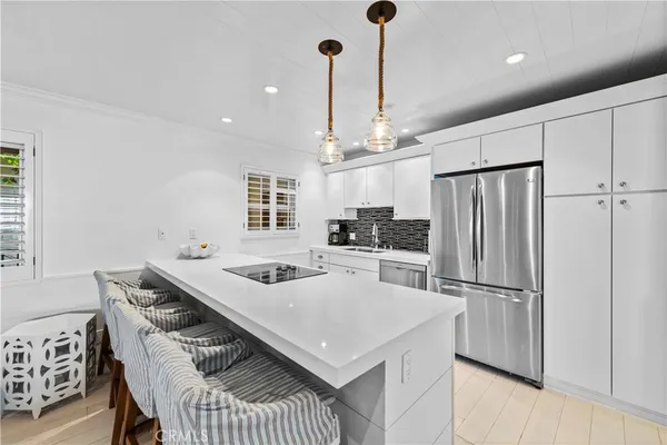 a kitchen with stainless steel appliances a table chairs and refrigerator