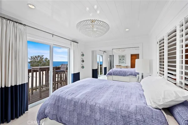 a bedroom with a large bed and a chandelier