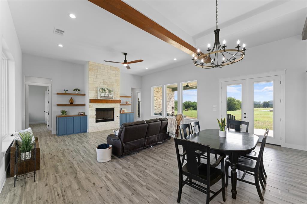 4411 Fm 751 Wills Point Wills Point, TX 75169 - Photo 12 of 40 Spacious living area featuring wood-finish flooring, a stone fireplace with a wood mantle, and built-in shelving