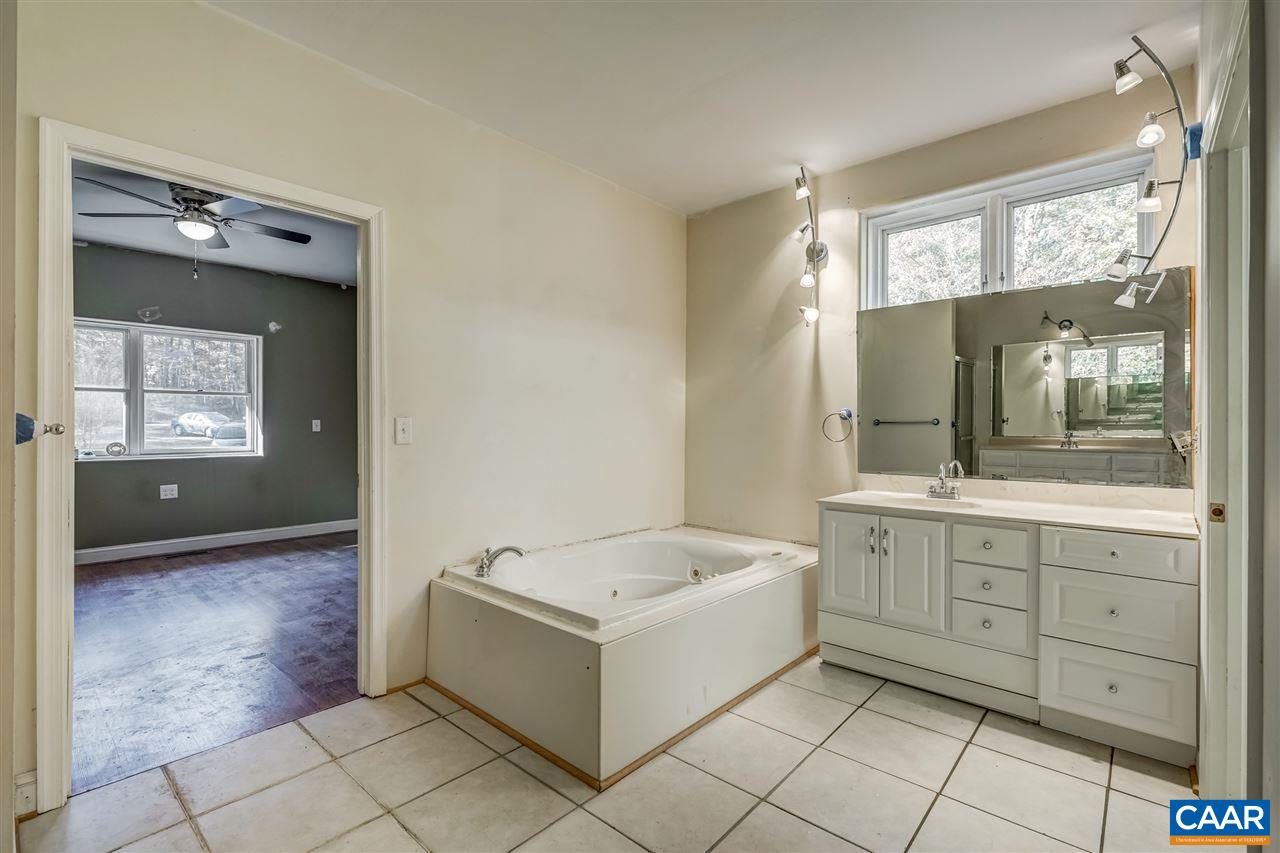 5595 New Line Road Gum Spring, VA 23065 - Photo 20 of 36 a bathroom with a tub sink and mirror