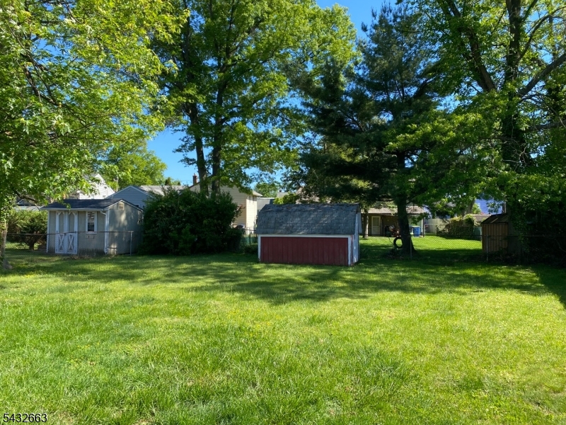 721 Lawrence Road Bound Brook, NJ 08805 - Photo 17 of 21 a view of a backyard with large trees and wooden fence