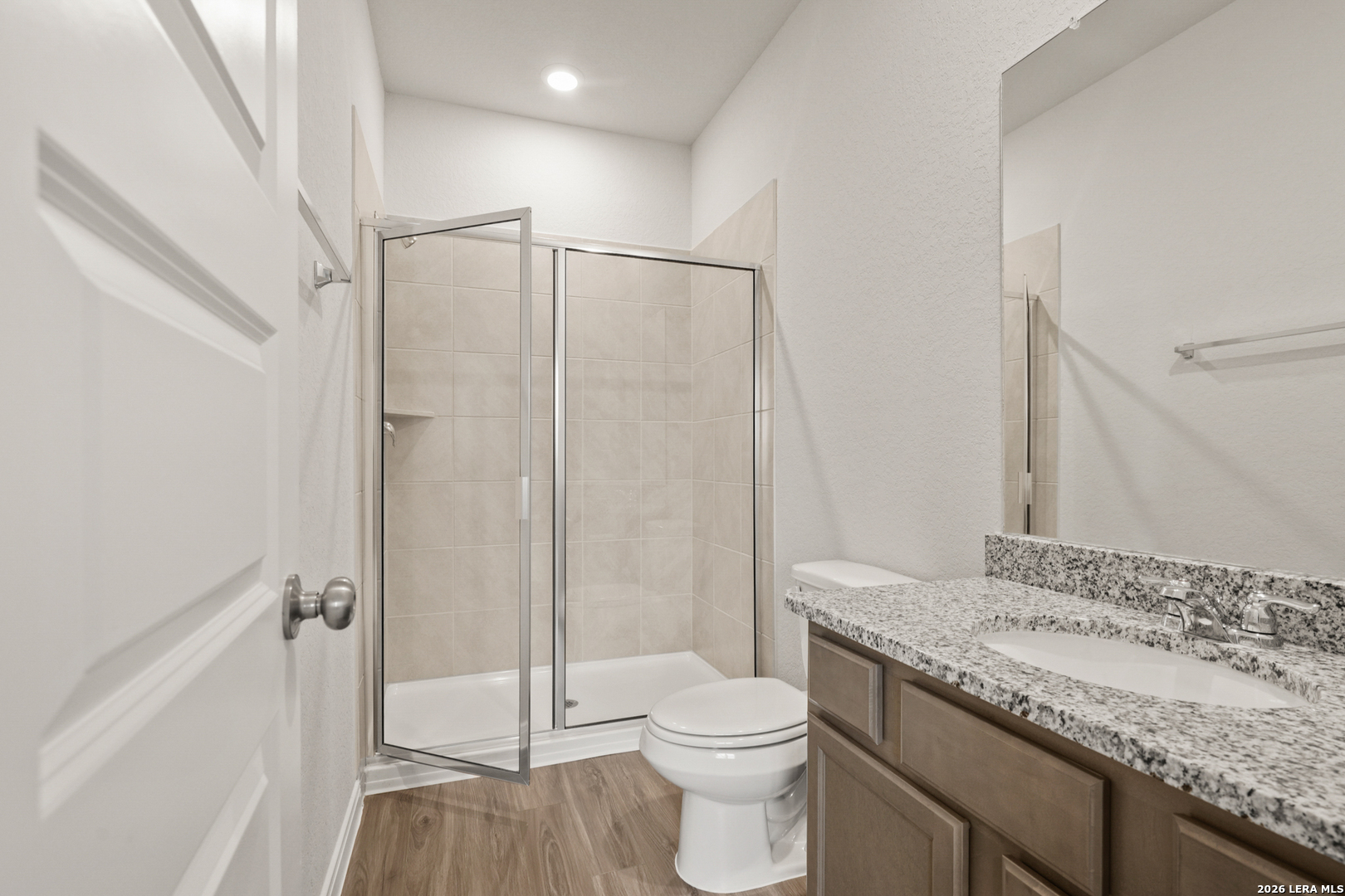 13627 Helton Pass St. Hedwig, TX 78152 - Photo 12 of 33 a bathroom with a granite countertop sink a toilet and shower