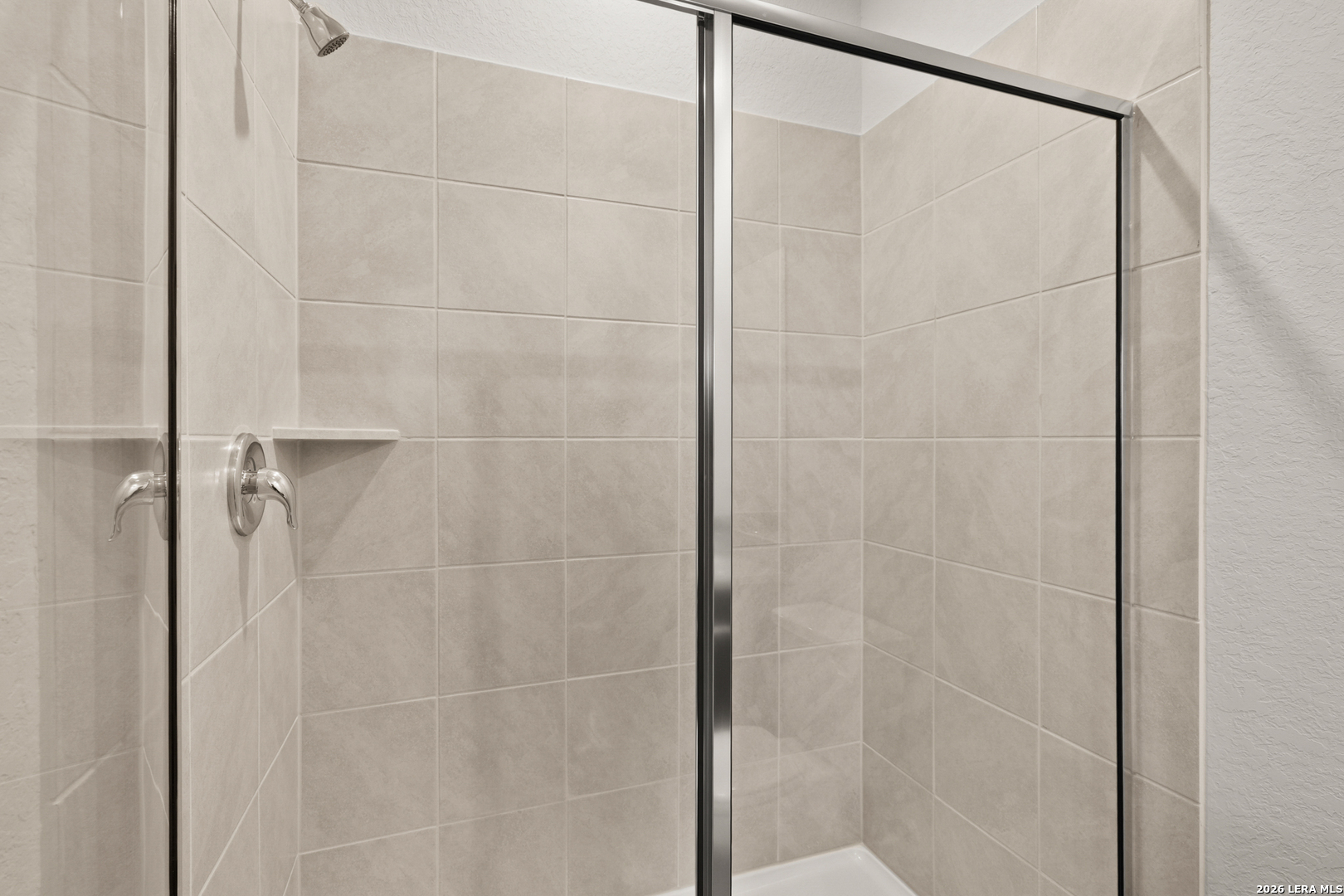 13627 Helton Pass St. Hedwig, TX 78152 - Photo 13 of 33 a bathroom with a glass shower door
