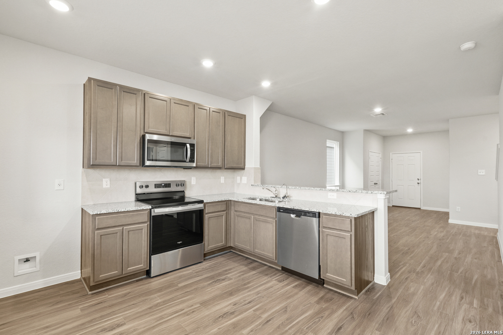 13627 Helton Pass St. Hedwig, TX 78152 - Photo 2 of 33 a large kitchen with cabinets wooden floor and stainless steel appliances
