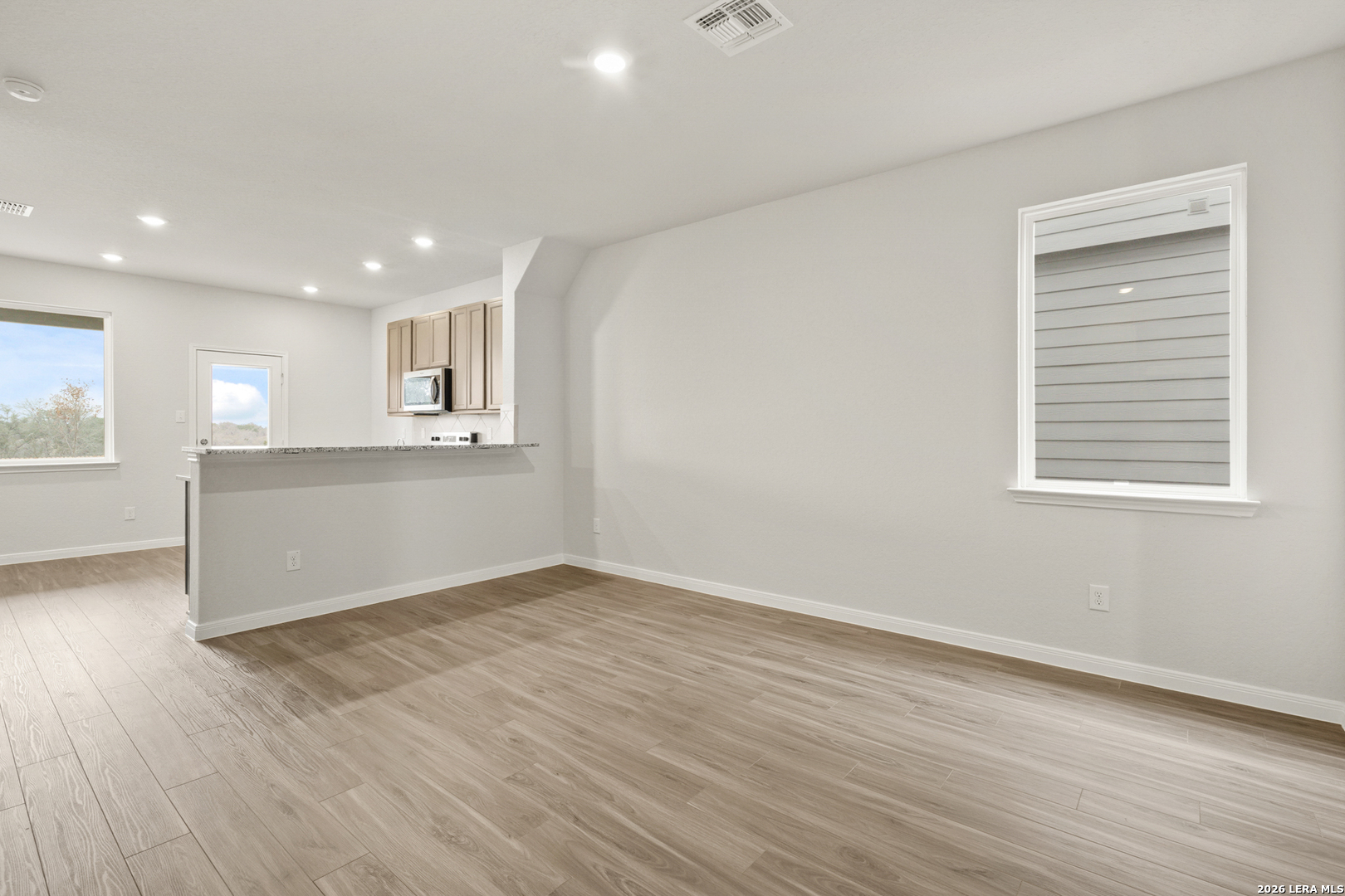 13627 Helton Pass St. Hedwig, TX 78152 - Photo 5 of 33 an empty room with wooden floor and windows