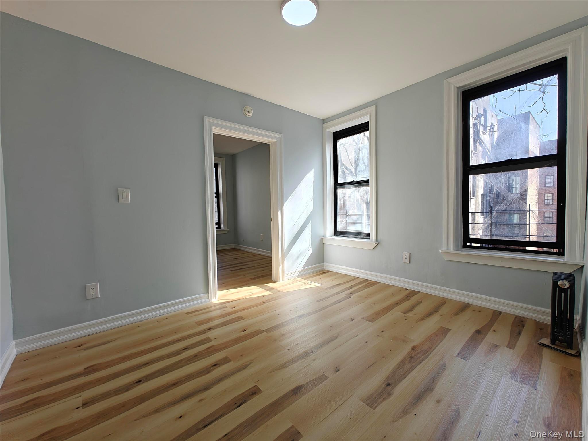 30 Macombs Place, Unit 44 Manhattan, NY 10039 - Photo 2 of 11 a view of an empty room with wooden floor and a window