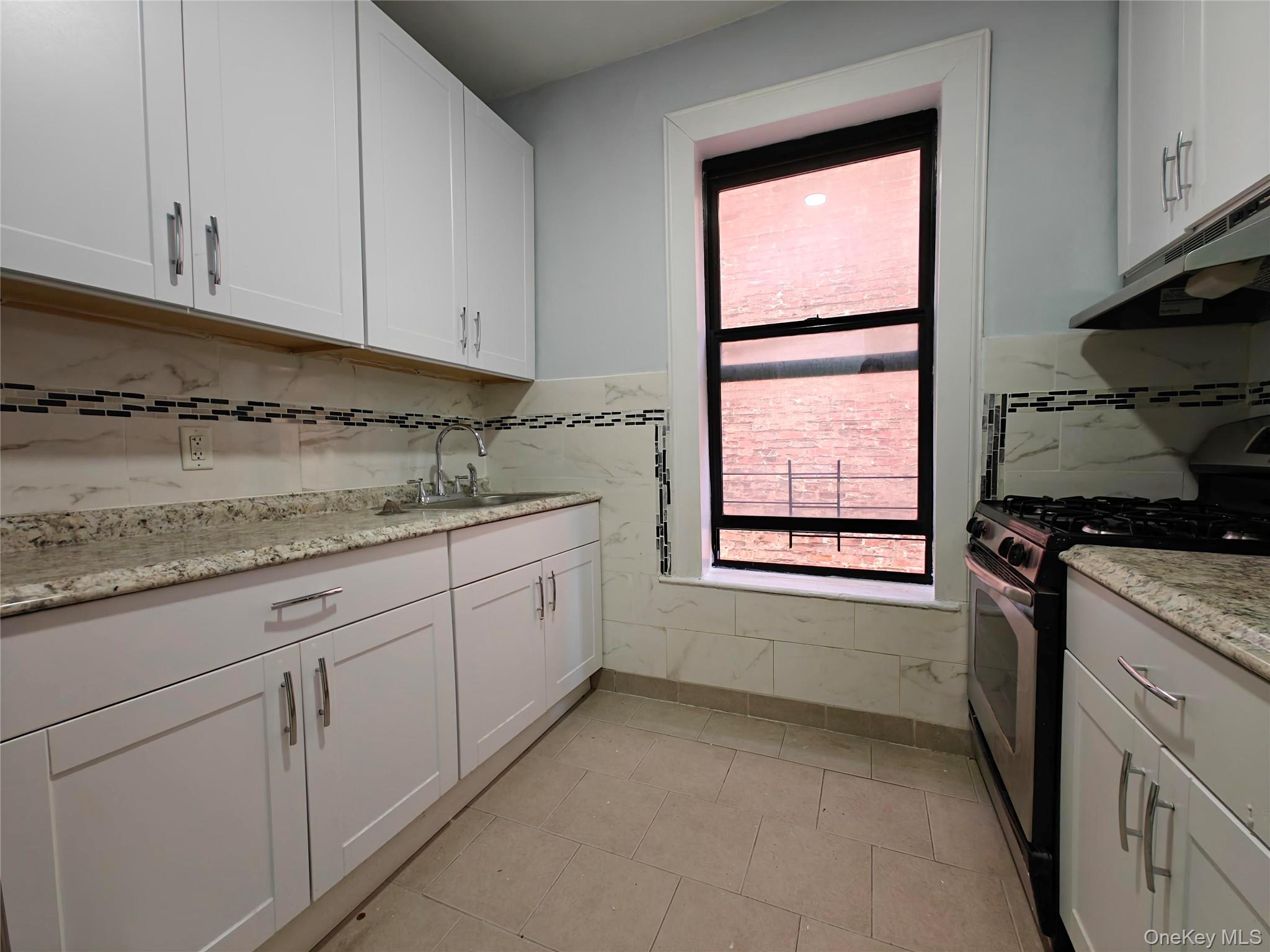 30 Macombs Place, Unit 44 Manhattan, NY 10039 - Photo 9 of 11 a kitchen with granite countertop white cabinets and white appliances