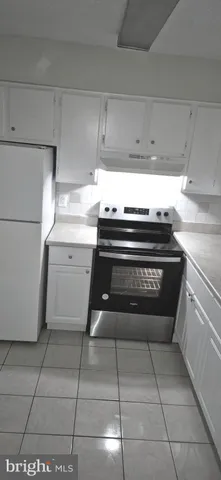 a stove top oven sitting inside of a kitchen