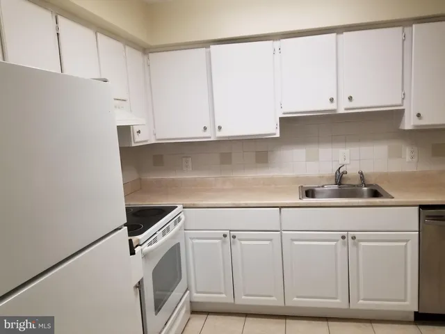 a kitchen with white cabinets and white appliances