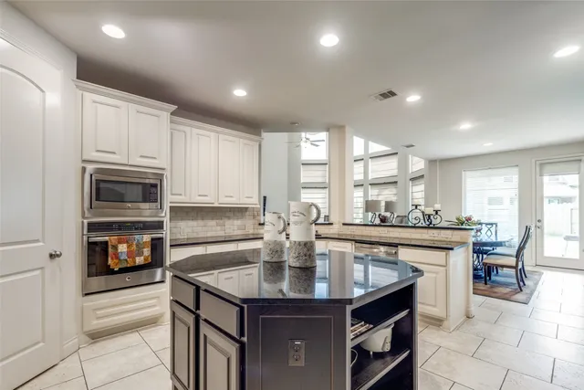 a kitchen with kitchen island granite countertop a stove and a sink