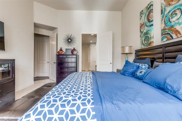 a bedroom with a bed and a lamp on dresser