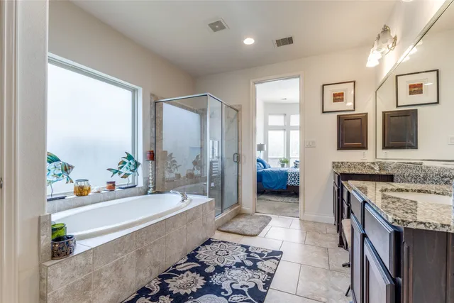 a spacious bathroom with a tub a sink and a large mirror