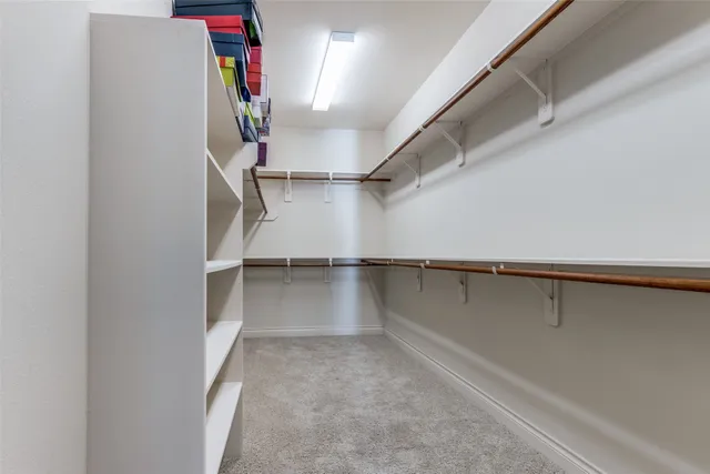 a view of walk in closet with empty racks