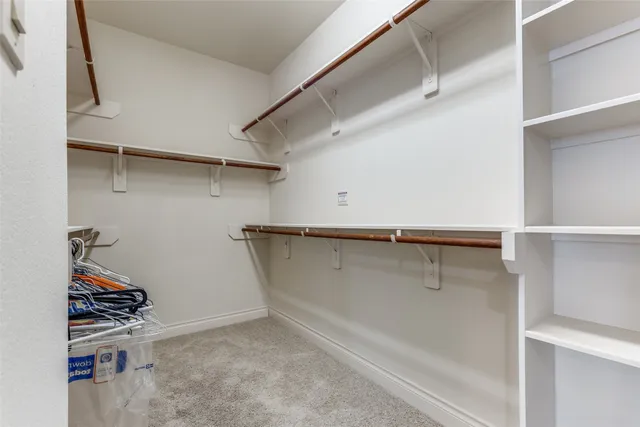 a view of walk in closet with clothes and shoes