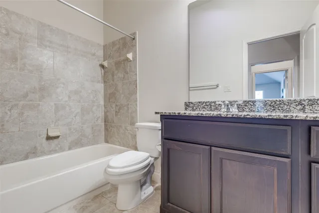 a bathroom with a granite countertop sink a toilet and bathtub