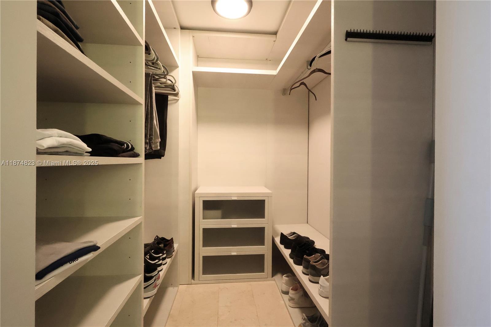 68 Southeast 6th Street, Unit 3607 Miami, FL 33131 - Photo 13 of 29 a view of walk in closet with clothes and shoes