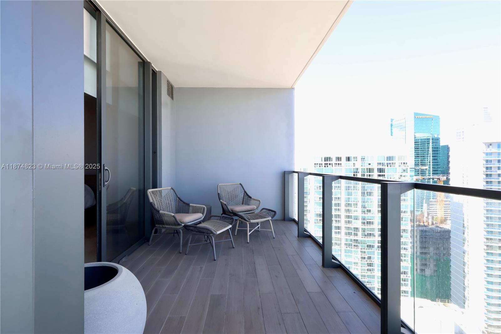 68 Southeast 6th Street, Unit 3607 Miami, FL 33131 - Photo 16 of 29 a view of a balcony with chair and wooden floor