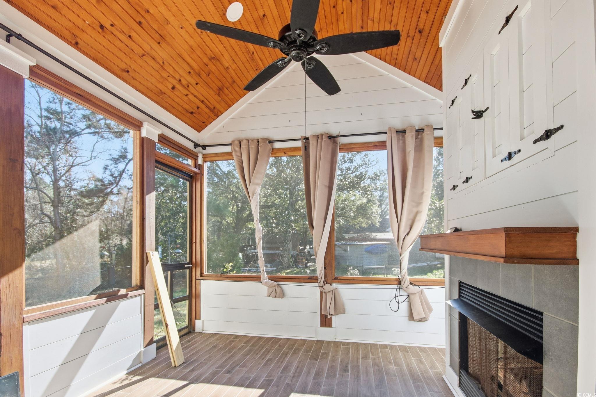1735 Rice Street Georgetown, SC 29440 - Photo 13 of 34 Unfurnished sunroom with a fireplace, a ceiling fan, lofted ceiling, and a wooden deck