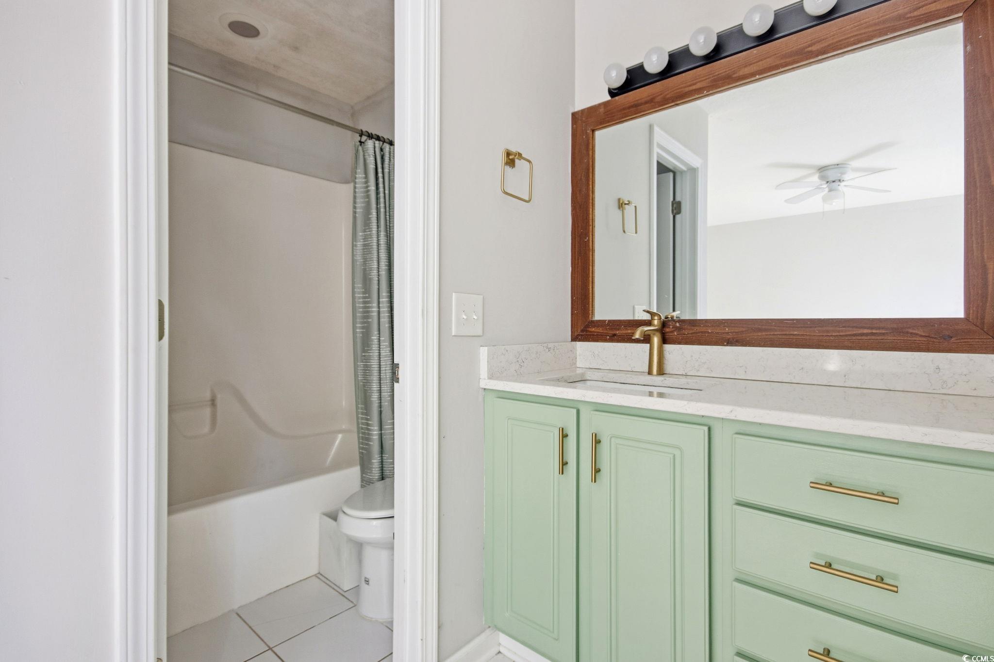1735 Rice Street Georgetown, SC 29440 - Photo 17 of 34 Full bathroom with vanity, shower / bath combination with curtain, light tile patterned flooring, and ceiling fan